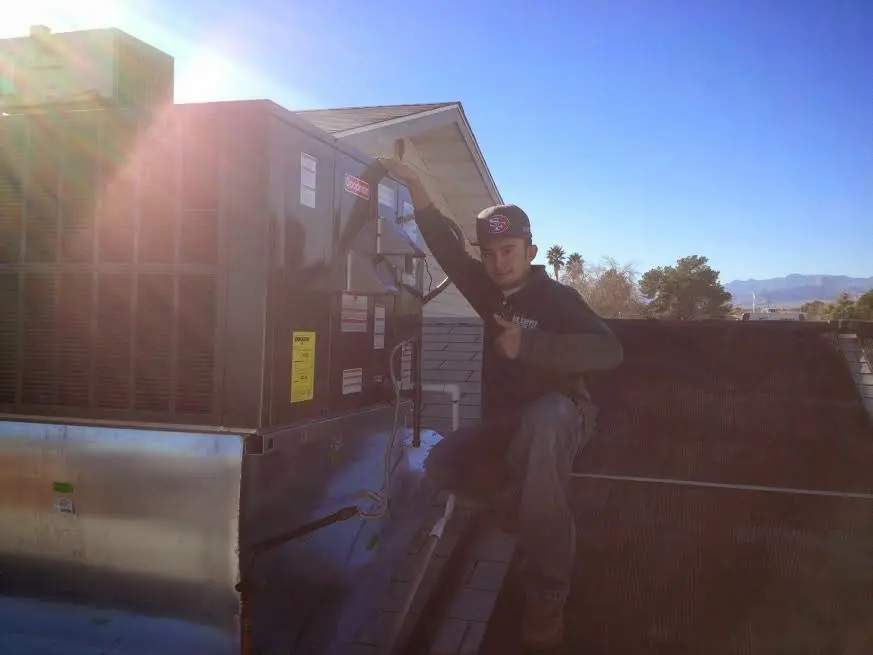 HVAC technician performing AC Tune-Up on a rooftop unit in Southborough